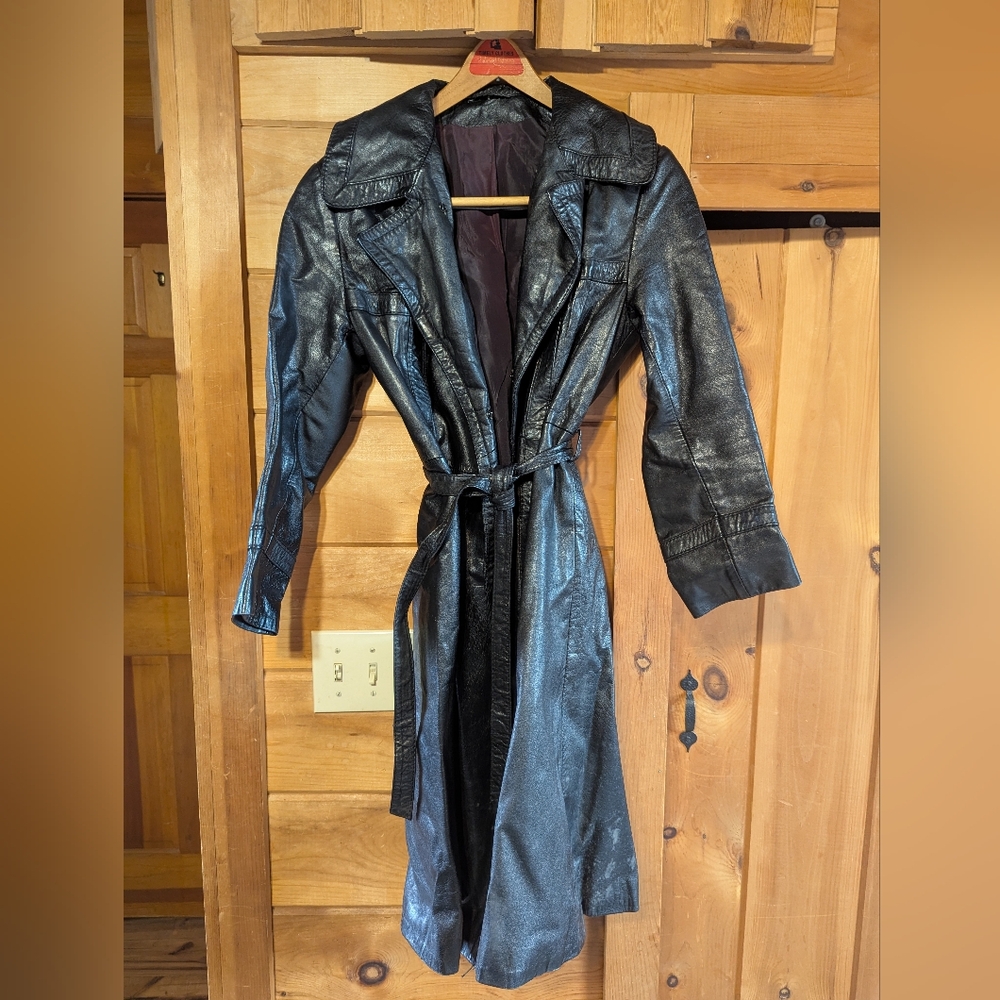 Vintage mid-thigh length black leather trench coat, size medium, tie belt.